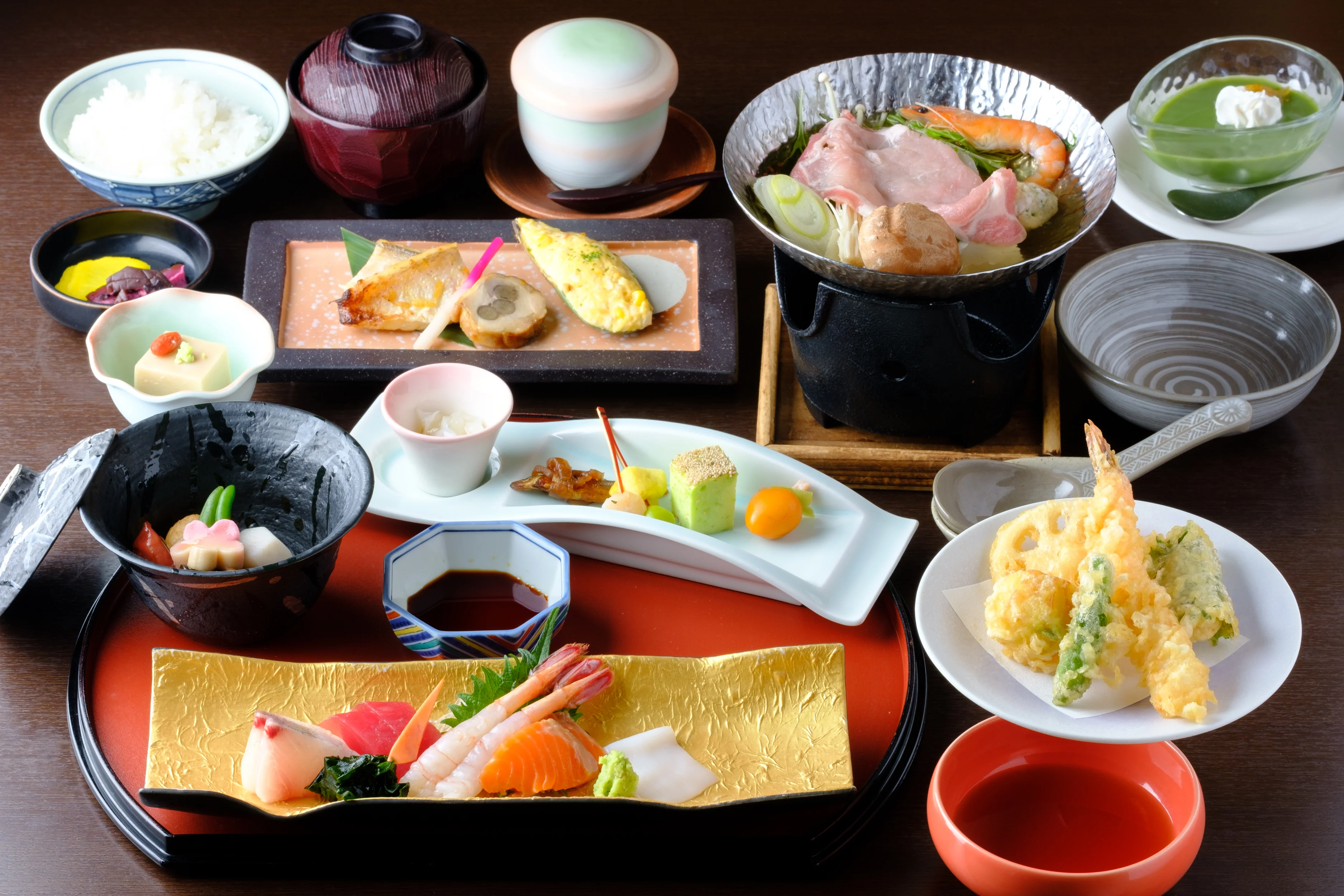 窓際の席に自然光が差し込み、白木の卓に懐石料理が一人前ずつ整えられた店内写真